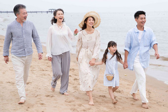 快乐的一家人在海滩上散步