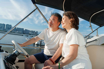 幸福的老年夫妇驾驶游艇出海