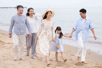 快乐的一家人在海滩上散步人高清相片