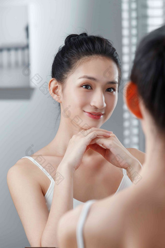 年轻女人照镜子护肤高质量摄影图