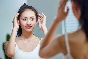 漂亮的年轻女人照着镜子梳头发中国氛围影相