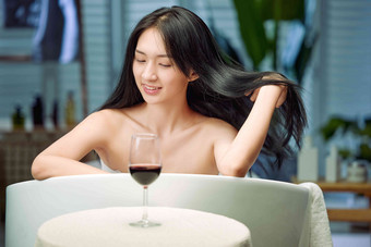 浴缸内漂亮的年轻女人和红酒