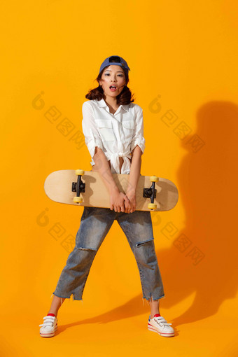 年轻女孩拿着<strong>滑板</strong>惊奇高端素材