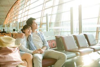 青年情侣坐在机场候机厅东方人写实素材