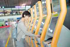 商务女士在机场使用自动售票机