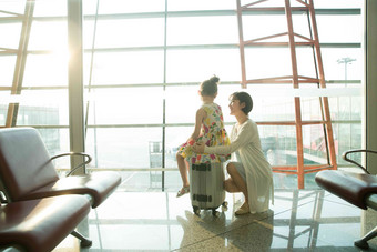 年轻妈妈和女儿从机场候机厅往外看中国人写实相片