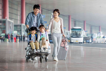 快乐家庭推着行李在机场母亲写实素材