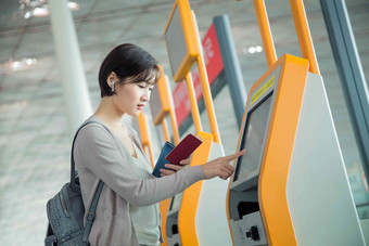 商务女士在机场使用自动售票机空运大楼高端摄影图