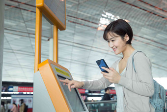 商务女士在机场使用自动售票机手指写实相片
