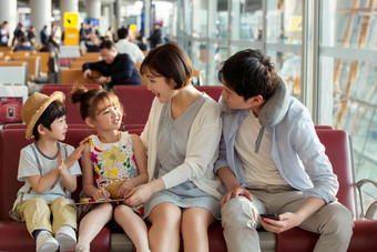 快乐家庭坐在机场候机厅户内拍摄