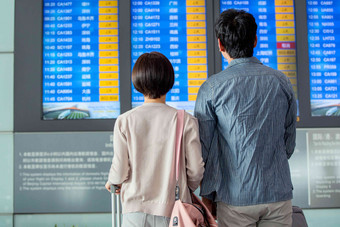 青年情侣在机场候机厅看航班表中国人高清摄影