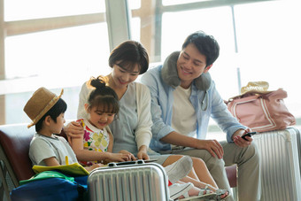 快乐家庭在机场候机厅里看平板电脑