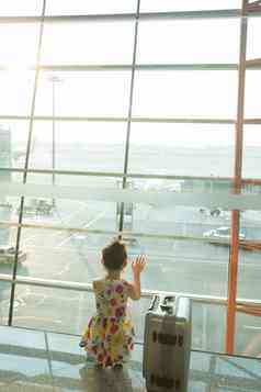 一个小女孩在机场候车厅往外看