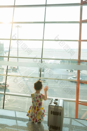 一个小女孩在机场候车厅往外看蹲写实照片