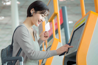 商务女士在机场使用自动售票机候机室照片
