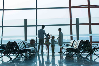 幸福家庭在机场候机厅往外看