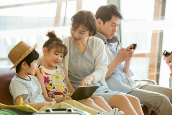 快乐家庭在机场候机厅里使用电子产品户内氛围场景
