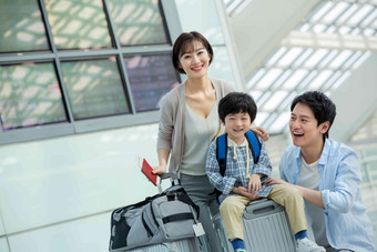 在机场的一家三口快乐旅行青年人高清照片