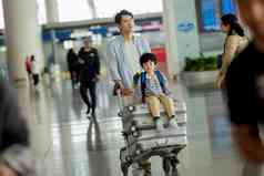 父子在机场候机厅推着行李
