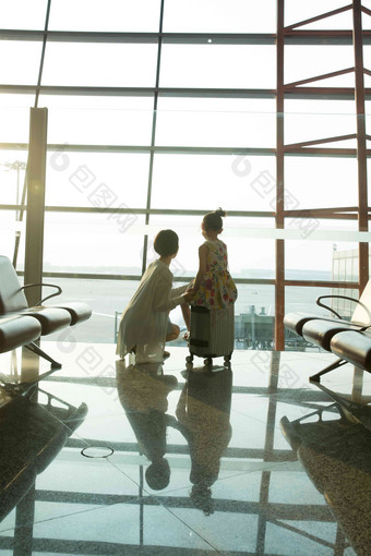 年轻妈妈和女儿从机场候机厅往外看中国清晰照片