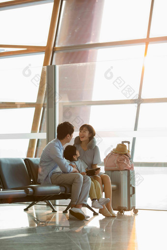 一家三口坐在机场候机大厅旅游氛围相片