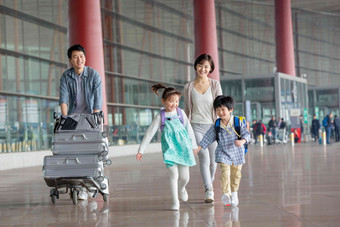 欢乐家庭在机场推着行李