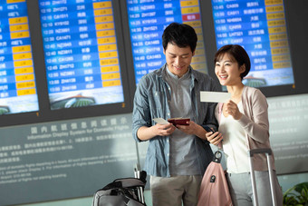 青年情侣在机场候机厅拿着机票