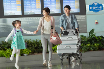 快乐家庭在机场推着行李旅行者高质量相片