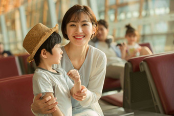 年轻妈妈和儿子坐在机场候机厅中国高端拍摄