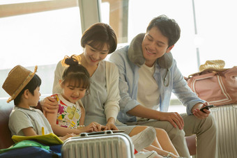 快乐家庭坐在机场<strong>候机厅</strong>里手机清晰素材