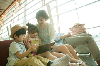 年轻妈妈和孩子们在机场候机厅看平板电脑中国高质量摄影