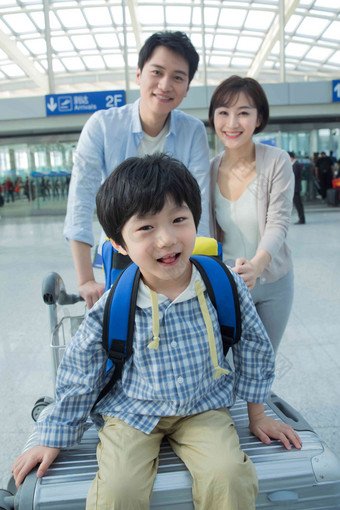 在机场的一家三口快乐旅行行李高端摄影图