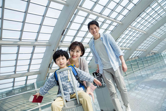 在机场的一家三口快乐旅行东方人写实相片