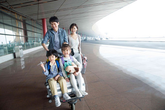 欢乐家庭在机场推着行李