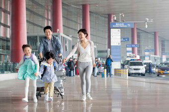 欢乐家庭在机场推着行李旅行者高清素材