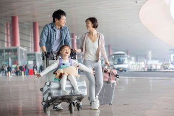 快乐家庭在机场推着行李男人清晰照片