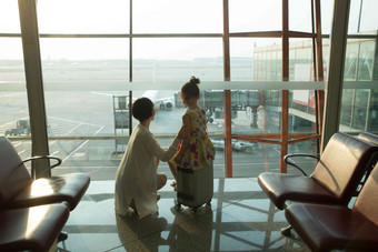 年轻妈妈和女儿从机场<strong>候机厅</strong>往外看日光写实镜头