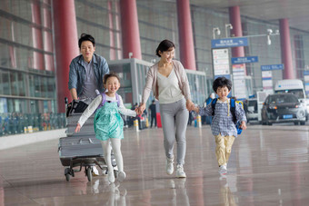 欢乐家庭在机场推着行李中国人写实影相