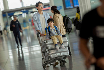 <strong>父子</strong>在机场候机厅推着行李交通方式高端照片