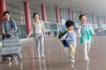 欢乐家庭在机场推着行李步行高清拍摄