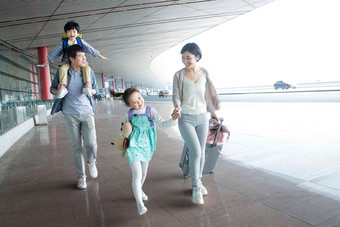 快乐家庭拿着行李在机场摄影高端图片