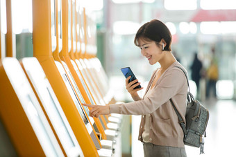 商务女士在机场使用自动售票机一个人高端素材