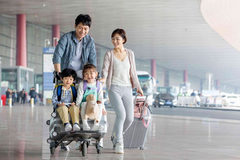 欢乐家庭在机场推着行李旅游氛围摄影