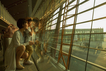 年轻妈妈和儿子从机场<strong>候机厅</strong>往外看旅途高质量摄影
