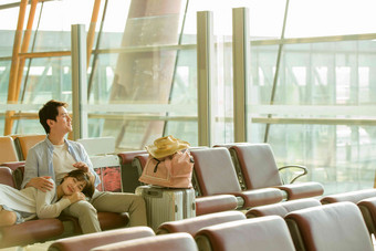青年情侣坐在机场候机厅人摄影图
