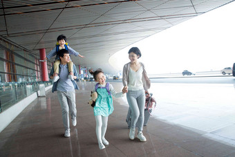 快乐家庭拿着行李在机场旅游写实图片