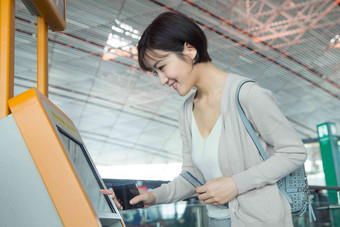 商务女士在机场使用自动售票机点击氛围图片