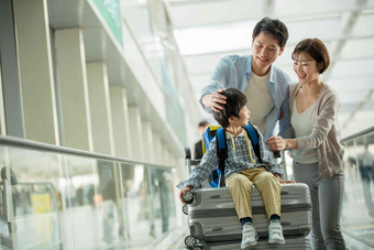 一家三口在机场推着行李中国人写实摄影