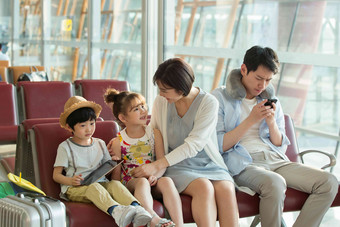 快乐家庭坐在机场候机厅里通讯照片