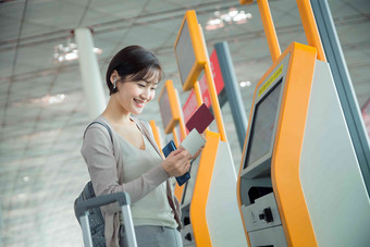 商务女士在机场使用自动售票机便利影相